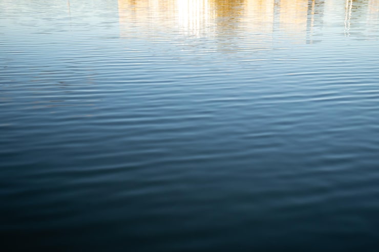 Ruhige Wasseroberfläche, die den Himmel spiegelt